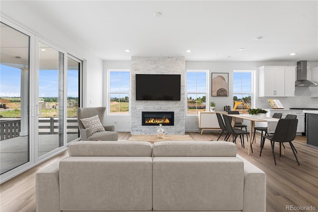 8863 Springsong Ln, Littleton, CO 80125 - living room featuring light wood-type flooring, recessed lighting, and a fireplace
