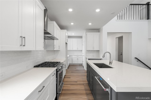 8863 Springsong Ln, Littleton, CO 80125 - kitchen featuring appliances with stainless steel finishes, wall chimney exhaust hood, white cabinetry, decorative backsplash, and recessed lighting