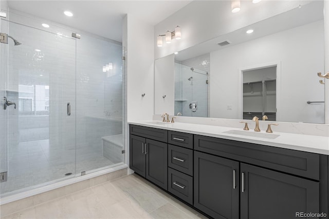 8863 Springsong Ln, Littleton, CO 80125 - bathroom featuring double vanity, a stall shower, a walk in closet, and recessed lighting