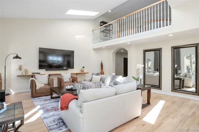 living room featuring high vaulted ceiling and light hardwood / wood-style floors