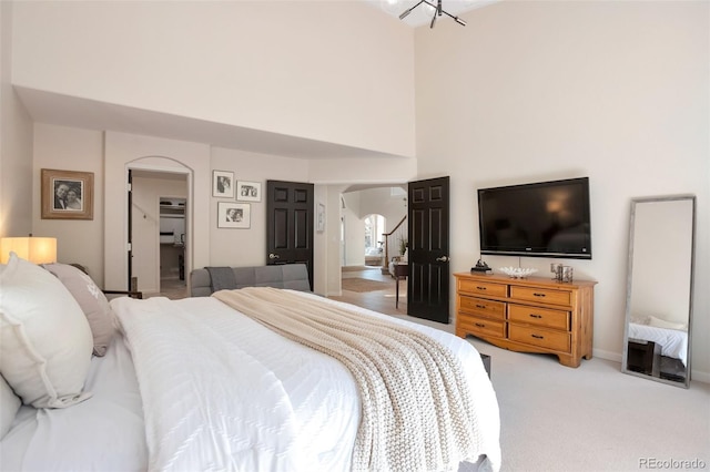 bedroom featuring a high ceiling and light carpet