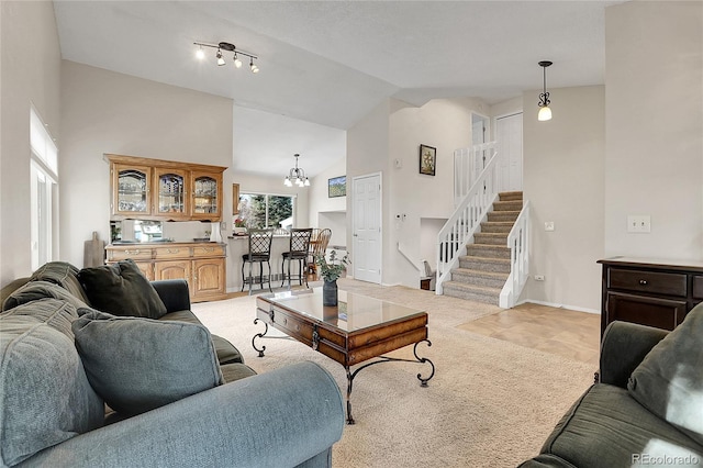 living room featuring light carpet, a chandelier, and lofted ceiling