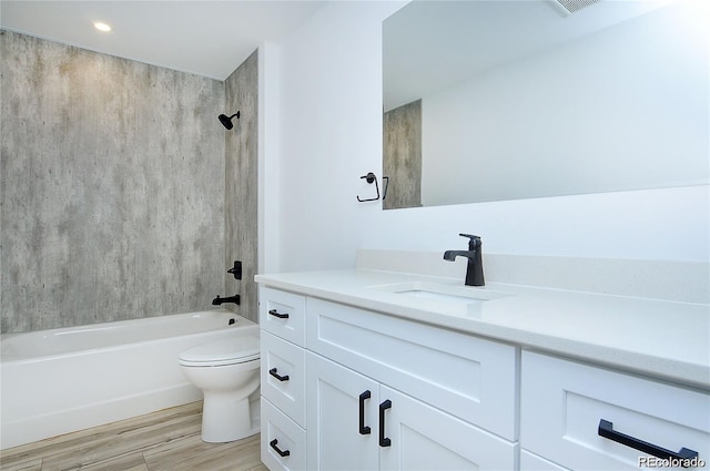 full bathroom featuring hardwood / wood-style flooring, vanity, toilet, and tiled shower / bath