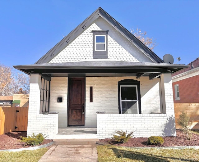 view of front of home featuring covered porch and brick siding