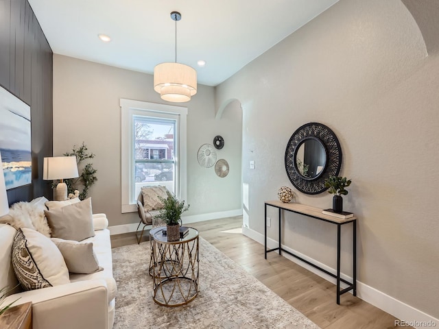 interior space with light wood-style flooring, arched walkways, baseboards, and recessed lighting