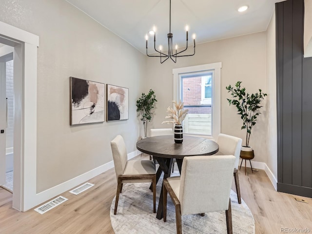 dining room with light wood-style floors, visible vents, and baseboards