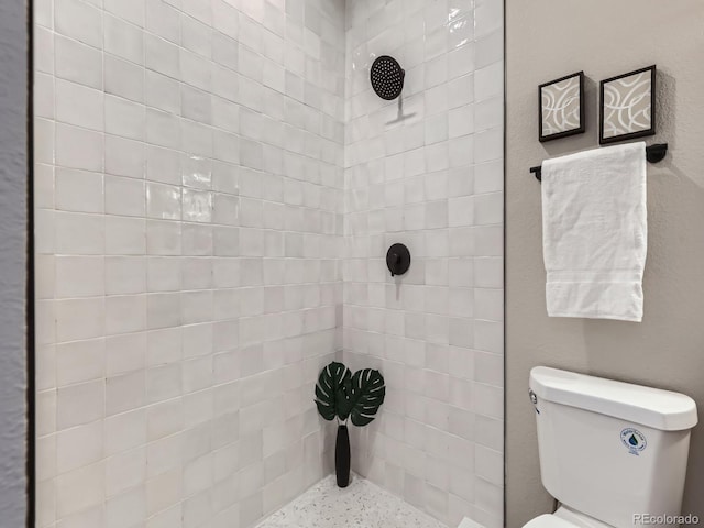 full bath featuring toilet and a tile shower