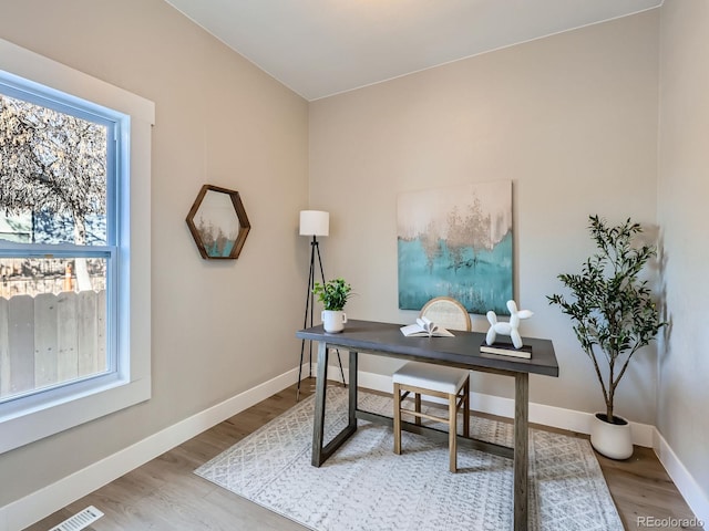 office area featuring visible vents, baseboards, and wood finished floors