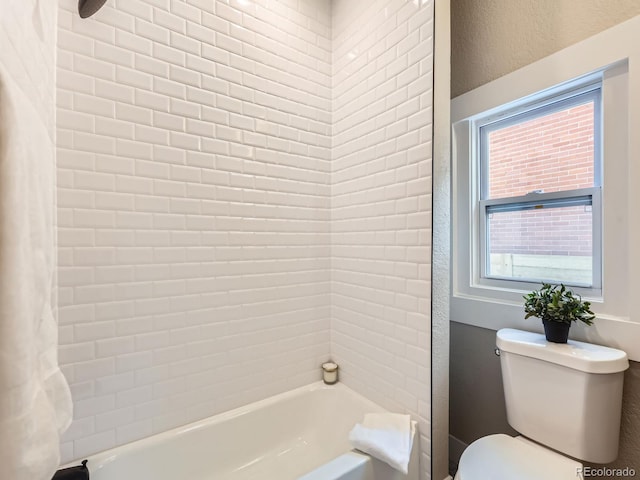 full bathroom featuring a textured wall, shower / bath combo, and toilet