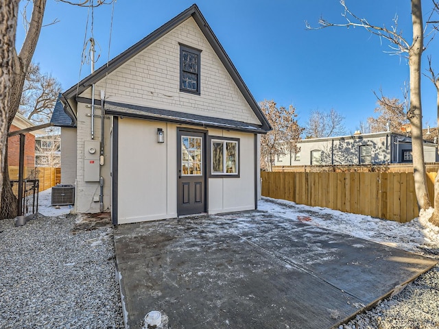 back of property featuring fence, central AC unit, and a patio