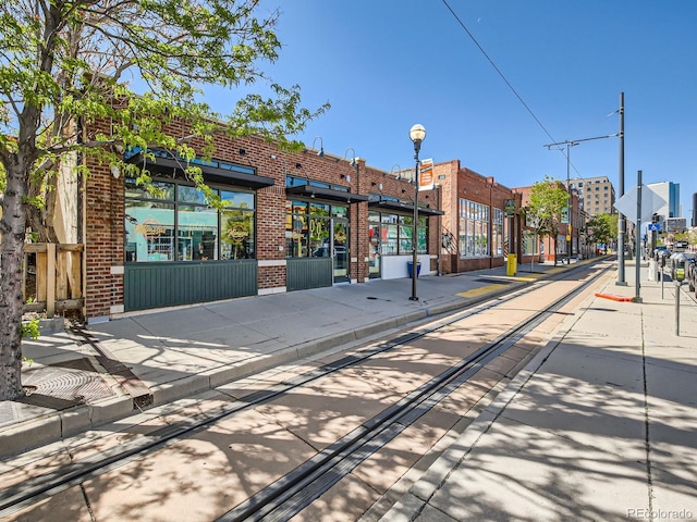 view of road featuring curbs, street lighting, and sidewalks