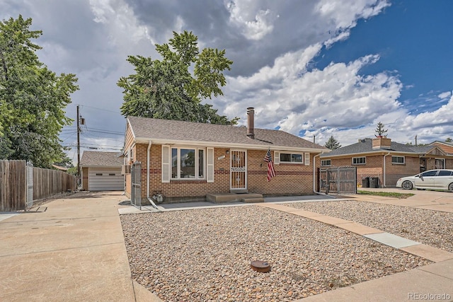 single story home featuring a garage and an outdoor structure