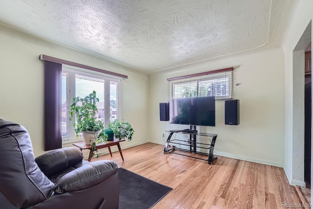 living room with hardwood / wood-style flooring, a wealth of natural light, and a textured ceiling
