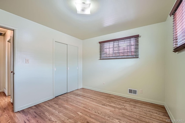 unfurnished bedroom featuring light wood-type flooring and a closet