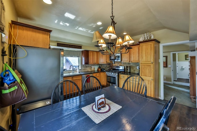 dining room featuring sink, dark hardwood / wood-style flooring, vaulted ceiling, and an inviting chandelier