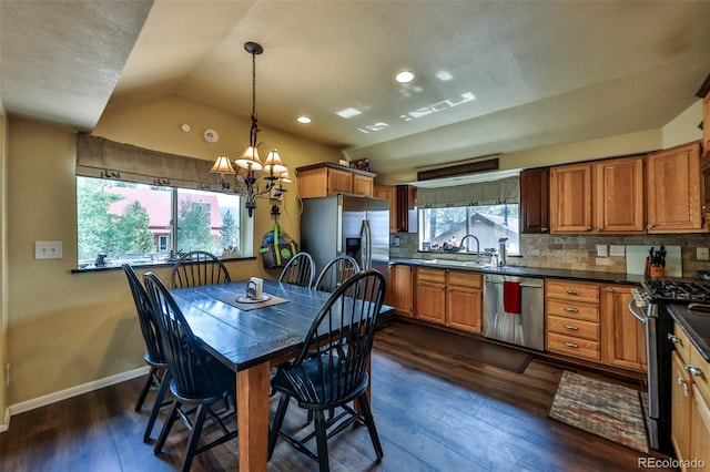 dining area featuring a notable chandelier, dark hardwood / wood-style floors, sink, and vaulted ceiling