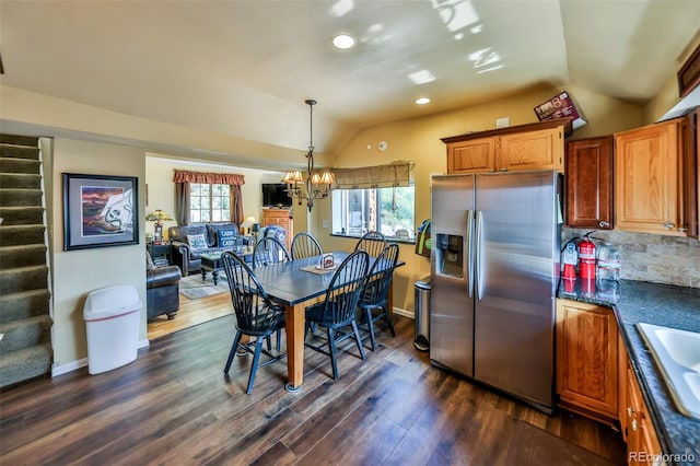 kitchen featuring an inviting chandelier, tasteful backsplash, dark hardwood / wood-style flooring, stainless steel fridge, and lofted ceiling