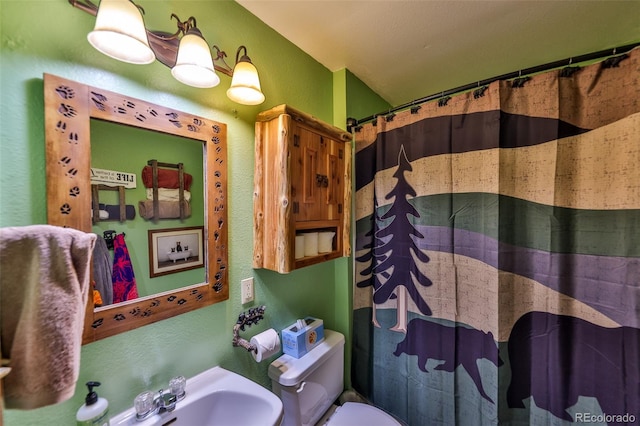 bathroom with a shower with shower curtain, toilet, and sink