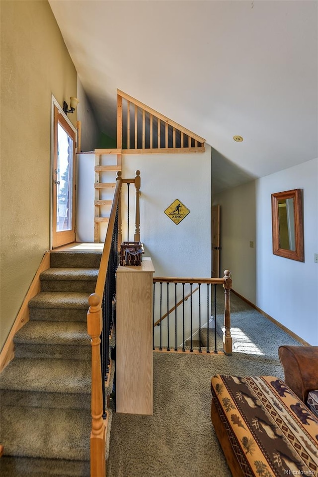 stairway featuring carpet and lofted ceiling