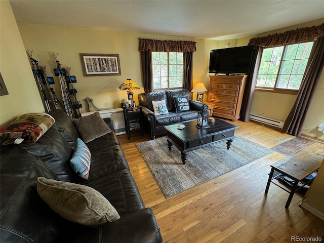 living room with light wood-type flooring and a baseboard heating unit