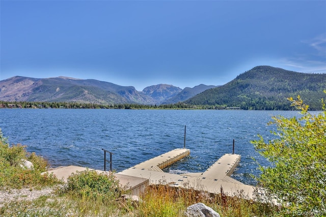 view of dock with a water and mountain view