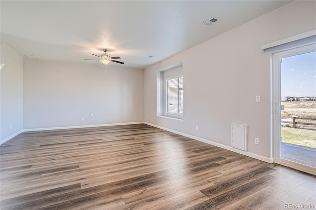 spare room with dark hardwood / wood-style floors and ceiling fan