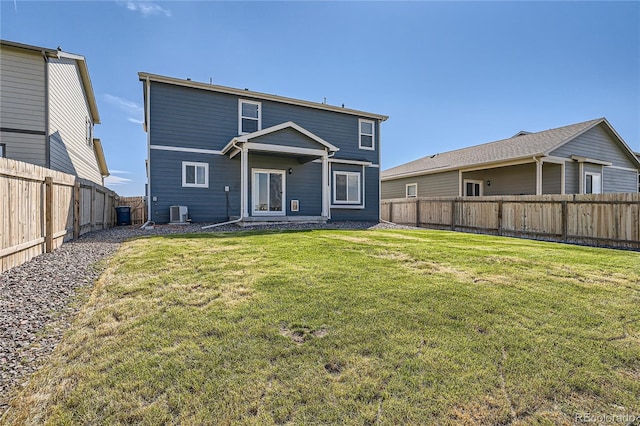 rear view of house with central AC and a yard