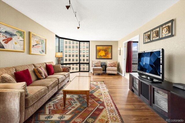 1625 Larimer St Unit 1605, Denver, CO 80202 - living area featuring wood finished floors, expansive windows, and rail lighting