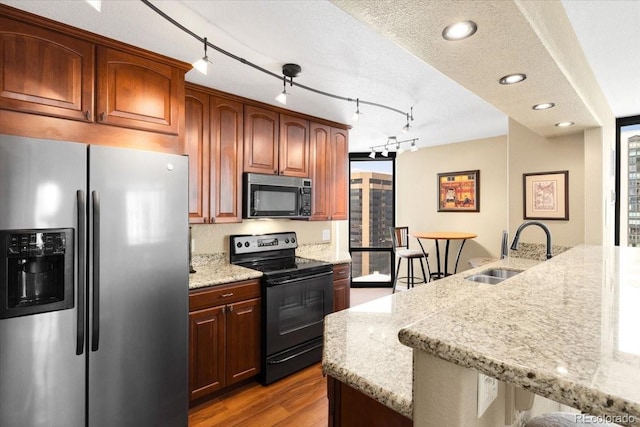 1625 Larimer St Unit 1605, Denver, CO 80202 - kitchen featuring black appliances, light wood-style flooring, light stone counters, healthy amount of natural light, and recessed lighting