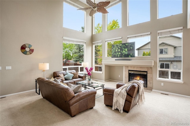 13078 Monaco Way, Thornton, CO 80602 - carpeted living area featuring a towering ceiling, baseboards, ceiling fan, and a tile fireplace