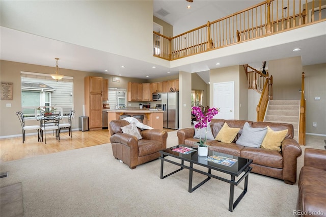 13078 Monaco Way, Thornton, CO 80602 - living room with a towering ceiling, healthy amount of natural light, light carpet, stairs, and baseboards