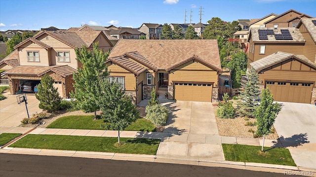 23871 E Ontario Pl, Aurora, CO 80016 - craftsman house with a residential view, concrete driveway, a tiled roof, and stone siding