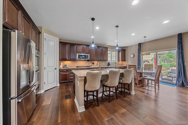 23871 E Ontario Pl, Aurora, CO 80016 - kitchen with stainless steel appliances, dark wood-type flooring, recessed lighting, healthy amount of natural light, and a kitchen breakfast bar
