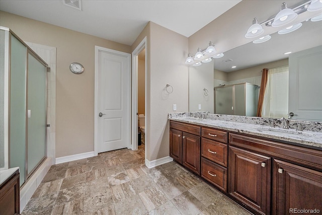 23871 E Ontario Pl, Aurora, CO 80016 - bathroom featuring a stall shower, double vanity, and stone finish floors