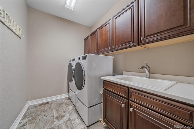 23871 E Ontario Pl, Aurora, CO 80016 - laundry room with cabinet space, washing machine and dryer, and light stone finish flooring