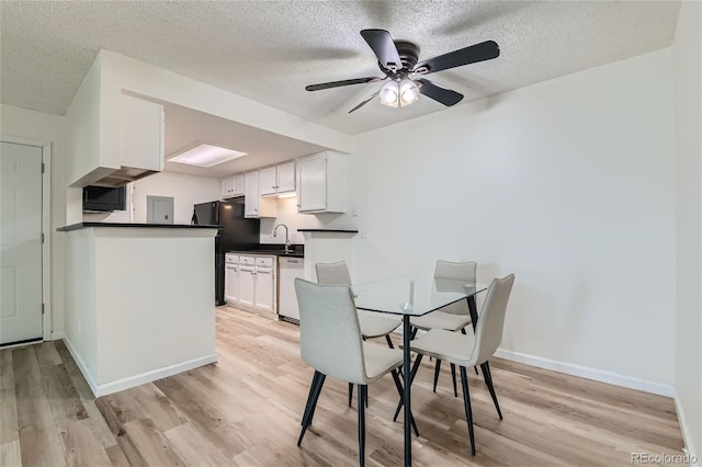 dining space featuring light hardwood / wood-style floors, a textured ceiling, sink, and ceiling fan