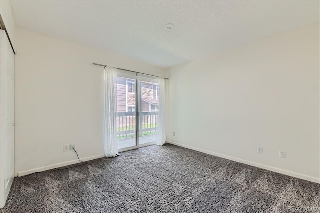 empty room with carpet flooring and a textured ceiling