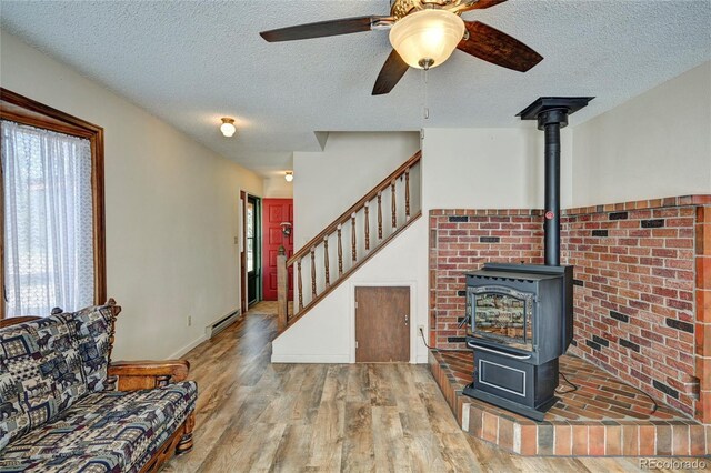 living room with ceiling fan, hardwood / wood-style floors, and a textured ceiling