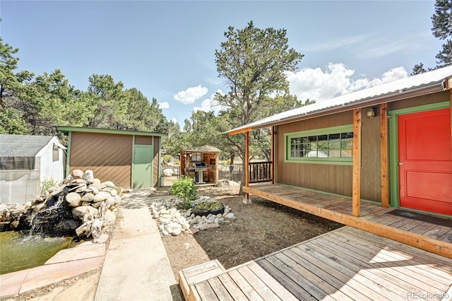 wooden deck with a storage unit and grilling area