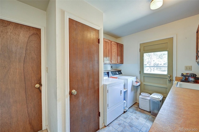 washroom with cabinets, separate washer and dryer, and sink