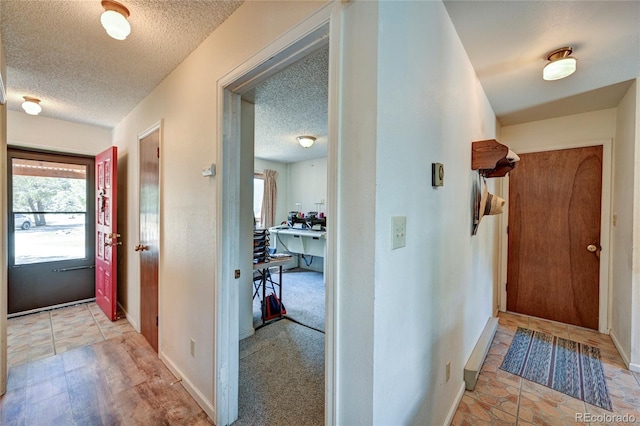 foyer entrance with light colored carpet and a textured ceiling