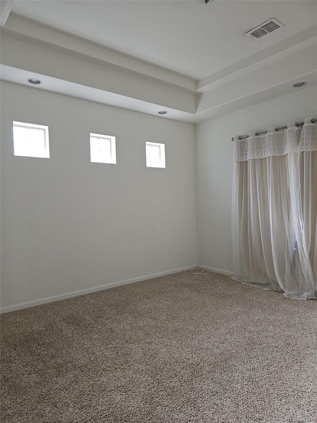 unfurnished room featuring carpet, visible vents, and baseboards