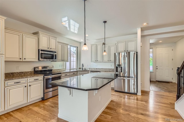 19753 E 54th Ave, Denver, CO 80249 - kitchen with appliances with stainless steel finishes, cream cabinetry, plenty of natural light, recessed lighting, and a center island
