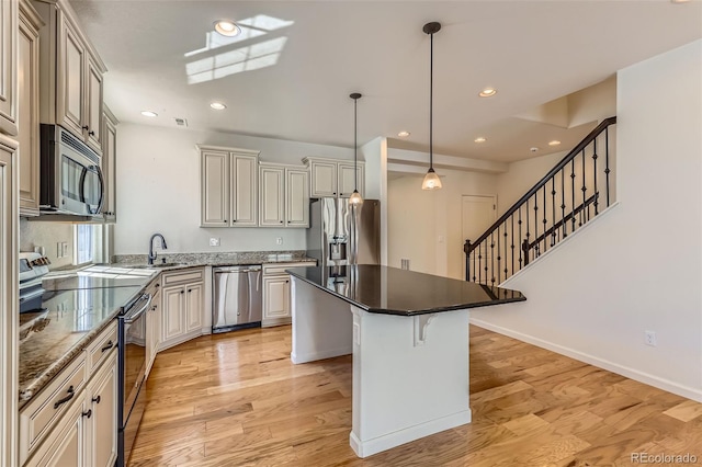 19753 E 54th Ave, Denver, CO 80249 - kitchen featuring appliances with stainless steel finishes, a kitchen island, light wood-style floors, recessed lighting, and a kitchen breakfast bar