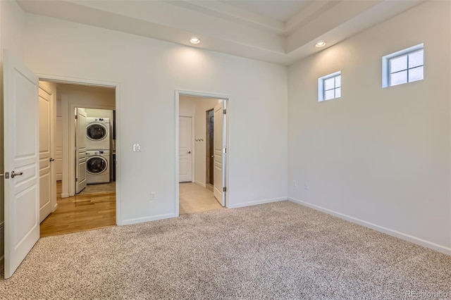 19753 E 54th Ave, Denver, CO 80249 - unfurnished bedroom with stacked washer / dryer, light colored carpet, recessed lighting, and connected bathroom
