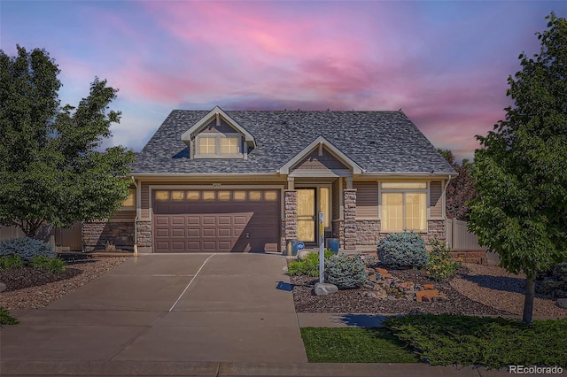 19753 E 54th Ave, Denver, CO 80249 - view of front of home featuring driveway, stone siding, and a garage