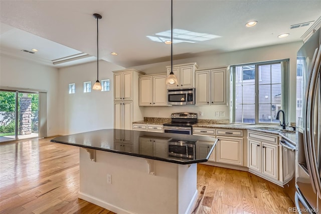 19753 E 54th Ave, Denver, CO 80249 - kitchen with stainless steel appliances, cream cabinetry, dark stone counters, light wood-style floors, and recessed lighting