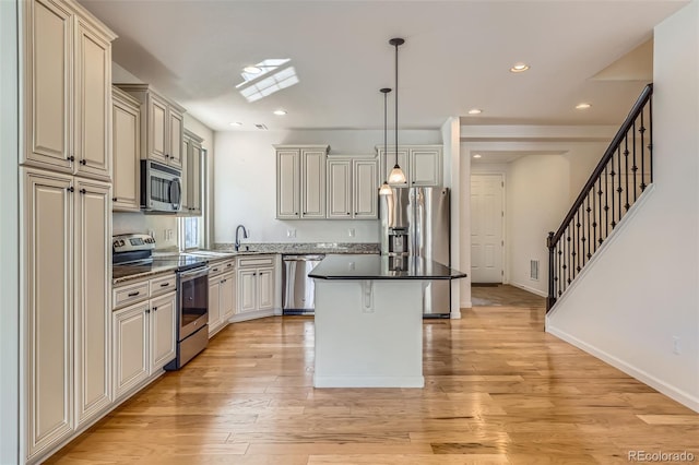 19753 E 54th Ave, Denver, CO 80249 - kitchen featuring appliances with stainless steel finishes, a center island, pendant lighting, light wood-style floors, and recessed lighting