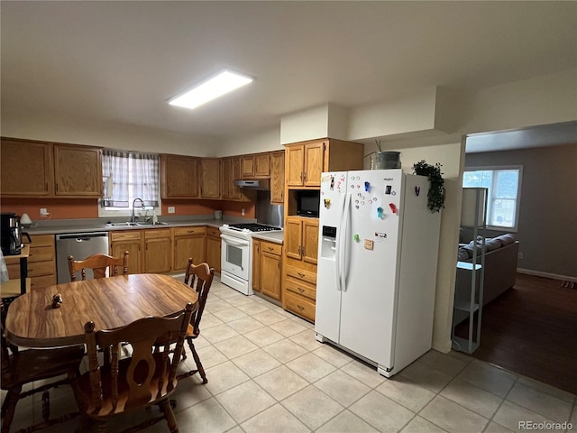 kitchen with light tile patterned flooring, plenty of natural light, sink, and white appliances