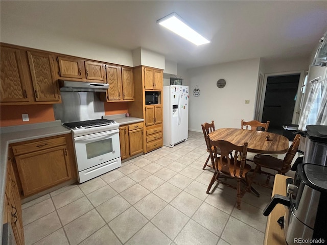 kitchen with light tile patterned floors and white appliances